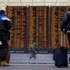 Dos viajeros comprueban la información de los vuelos en las pantallas del aeropuerto Charles de Gaulle, en Roissy (Francia).-Foto: EFE