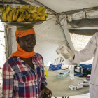 Un trabajador sanitario comprueba el estado de varias personas en la frontera de Nimule, en Uganda.-AFP / AKUOT CHOL