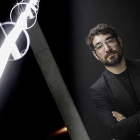 Solimán López posa al lado de la pieza de luz que materializa la estela dejada por un globo sonda lanzado al espacio hasta que se perdió su pista.-SANTI OTERO