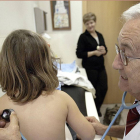 Un médico ausculta a una niña en la consulta en una imagen de archivo.-EL MUNDO