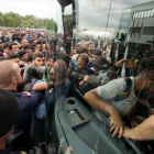Refugiados suben a un autocar cerca de Heiligenkreuz, en la frontera entre Austria y Hungría, ayer.-AP / CHRISTIAN BRUNA