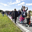 Un gran grupo de inmigrantes, sobretodo sirios, andan por una carretera en Dinamarca en dirección a Suecia, su destino.-REUTERS / SCANPIX DENMARK