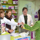 La farmacéutica Reyes Puerta (centro), atiende a una clienta junto a dos de sus empleadas en Quintanar de la Sierra.-R.F.