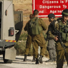 Soldados israelís a la entrada de una localidad palestina de Yatta, de donde salieron los dos atacantes.-AFP HAZEM BADER