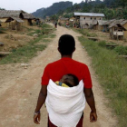 Una mujer congoleña se dirige caminano con su hijo en la espalda hacia la aldea de Luvungi.-AFP / MARC HOFFER