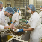 El chef Ricardo Temiño (en primer plano) coloca el lechazo en un plato ante la mirada del jefe de cocina del HUBU, Víctor Hernando y de un grupo de trabajadoras de la cocina del hospital.-ISRAEL L. MURILLO