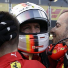 Sebastian Vettel es felicitado por dos de sus mecánicos tras lograr su tercera pole consecutiva de la temporada.-AP / LUCA BRUNO