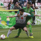 Iker Hernández protege el balón ante la presión de un jugador del Racing de Santander.-RAÚL G. OCHOA
