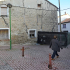 Una vecina pasa por delante de una de las casas donde se ve claramente el deterioro por las grietas.-ISRAEL L. MURILLO