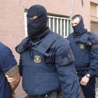 Imagen cedida por la Cadena Ser, en la que dos mossos se llevan detenido, en Santa Coloma de Gramenet, a uno de los presuntos miembros de la banda de Latin Kings desarticulada este miércoles.-Foto: CADENA SER