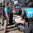 Dos agentes de la Policía Local resuelven las dudas de unos turistas en el centro de la ciudad.-ISRAEL L. MURILLO