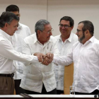 Raúl Castro sostiene las manos estrechadas del presidente de Colombia, Juan Manuel Santos, y del líder de las FARC, Rodrigo Londoño, alias 'Timochenko', este miércoles en La Habana.-EFE / ORLANDO BARRIA