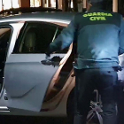 Un agente de la Guardia Civil junto al vehículo de los detenidos.-ECB