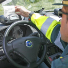 Un agente imprime una multa desde un vehículo en un control en carretera.-ISRAEL L. MURILLO