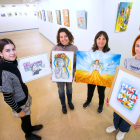 Posan con sus obras Sofía Pavón, Anzhelika Svirska y Olesia Kotelevska. Les acompaña Virginia, una voluntaria del equipo que porta el cuadro de Olena Hontar. TOMAS ALONSO