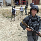 Un policia afgano asegura la zona tras el ataque suicida perpetrado contra un autobus de la policia a las afueras de Kabul.-HEDAYATULLAH AMID