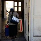 Una refugiada entra con sus pertenencias en el centro de Wilmersdorfer.-ROSA MASSAGUÉ