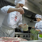 Óscar Barreno y la jefa de cocina Ana Rosa Cuadrado mientras trabajan en la cocina del Rivas (Salamanca).-ENRIQUE CARRASCAL