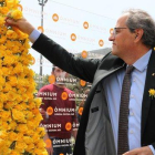 El presidente Quim Torra coloca una rosa amarilla en el mural de Òmnium.-BLANCA BLAY (ACN)