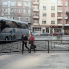 Dos viandantes transitan por la carretera por la presencia de la valla.-ECB