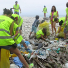 Voluntarios recogen restos en una playa de Vizcaya.-ECB