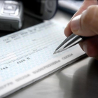 Firma de un cheque en una entidad bancaria.-123RF