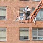 Imagen de unos trabajadores sobre la plataforma de una grúa.-ISRAEL L. MURILLO