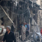 Miembros de la defensa civil siria y otras personas inspeccionan los edificios destrozados tras un bombardeo en el barrio de Al-Qaterji, controlado por los rebeldes, en Alepo, el 11 de octubre.-REUTERS / ABDALRHMAN ISMAIL