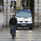 Imagen de un ciclista circulando ayer por el Espolón con una furgoneta de la Policía Local al fondo.-RAÚL G. OCHOA