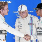 Rosberg, autor de la pole, saluda sonriente a un menos risueño Hamilton (2º) ante Bottas (3º), ayer en Austin.-Foto:  EFE / SRDJAN SUKI
