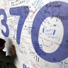 AUS01. KUALA LUMPUR (MALASIA), 30/07/2015.- Fotografía de archivo del 13 de marzo de 2014 de un hombre escribiendo mensajes en honor a las víctimas del vuelo MH370 de Malaysia Airlines en el aeropuerto internacional de Kuala Lumpur (Malasia).-EFE/MAK REMISSA