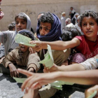Niños yemenís presentan documentos para recibir las raciones de alimentos proporcionadas por una oenegé local en Saná.-HANI MOHAMMED (AP)