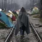 Un refugiado envuelto en una manta, en un campo de refugiados en la frontera entre Grecia y Macedonia, cerca de Idomeni (Grecia), este jueves.-EFE / YANNIS KOLESIDIS