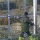 Un hombre y su hijo pasean junto a la valla que impide a la finca en la que se encuentran los pueblos abandonados de Fuente Humorera y Rioseco.-M.P.H.