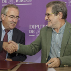 Ángel Carretón (izquierda) y Julio Herrero se estrechan la mano tras firmar el acuerdo en la Diputación.-SANTI OTERO