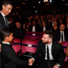 El hijo de Cristiano saluda a Messi en presencia de su padre y Antonella, en Londres.-AFP / BEN STANSALL