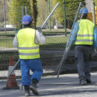 Dos trabajadores colocando una valla en una obra de acondicionamiento de la vía pública.-RAÚL G. OCHOA