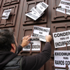 Un hombre cuelga carteles pidiendo la excomunión de Ramos Gordón en el Arzobispado de Astorga. ICAL
