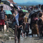 Un joven refugiado rohingya lleva a cuestas un hombre mayor en una zona cercana al lado bangladesí de la frontera con Birmania, tras cruzar el río Naf, el 17 de octubre.-AFP / MUNIR UZ ZAMAN