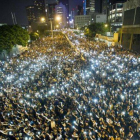 Manifestantes estudiantiles sostienen sus teléfonos  en una muestra de solidaridad durante las protestas frente a la sede del Consejo Legislativo de Hong Kong.-Foto: AFP / XAUME OLLEROS