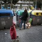 Una mujer deposita residuos en contenedores.-ARCHIVO