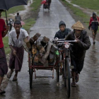 Una familia de rohingyas huye de las inundaciones en el 2014.-GEMUNU AMARASINGHE / AP
