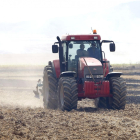 Dos personas en un tractor trabajan en el campo.-ISRAEL L. MURILLO