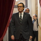 Artur Mas entra en el hemiciclo del Parlament, con Antonio Baños (CUP) al fondo.-JULIO CARBÓ