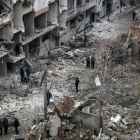 Vecinos inspeccionan los edificios en ruinas tras varios bombardeos el día anterior en Duma, feudo rebelde de Guta Oriental (Siria), el 22 de febrero.-/ EFE / MOHAMMED BADRA
