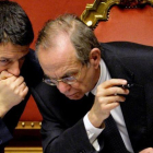 Renzi (izquierda) habla con el ministro de Economía, Pier Carlo Padoan, durante un debate parlamentario en el Senado, el 24 de febrero del 2014, en Roma.-AFP / ANDREAS SOLARO