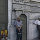 Pensionistas esperan para cobrar frente a un banco de Atenas (Grecia).-Foto:   EFE / YANNIS KOLESIDIS