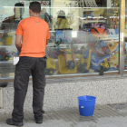 Imagen de un trabajador limpiando un escaparate.-ISRAEL L. MURILLO