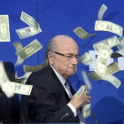 Un intruso ha irrumpido en la rueda de prensa del presidente de la FIFA y le ha lanzado un fajo de billetes.-Foto: AP