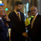 Gerard Piqué (c) saluda al presidente del Banco de Sabadell, Josep Oliu (d), en presencia del CEO y consejero delegado del GSMA, John Hoffman (i) tras la cena de bienvenida al Mobile World Congress (MWC).-QUIQUE GARCÍA (EFE)